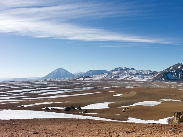 The mountainous scenery of Chile’s Chajnantor Plateau, with snow and ice scattered over the barren terrain. Photo by the ALMA.